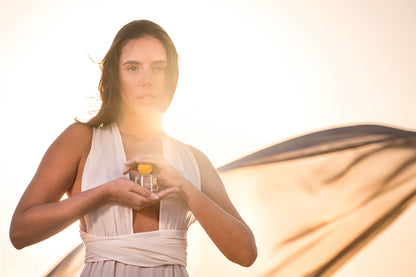 A woman holding the Delos eau de parfume.