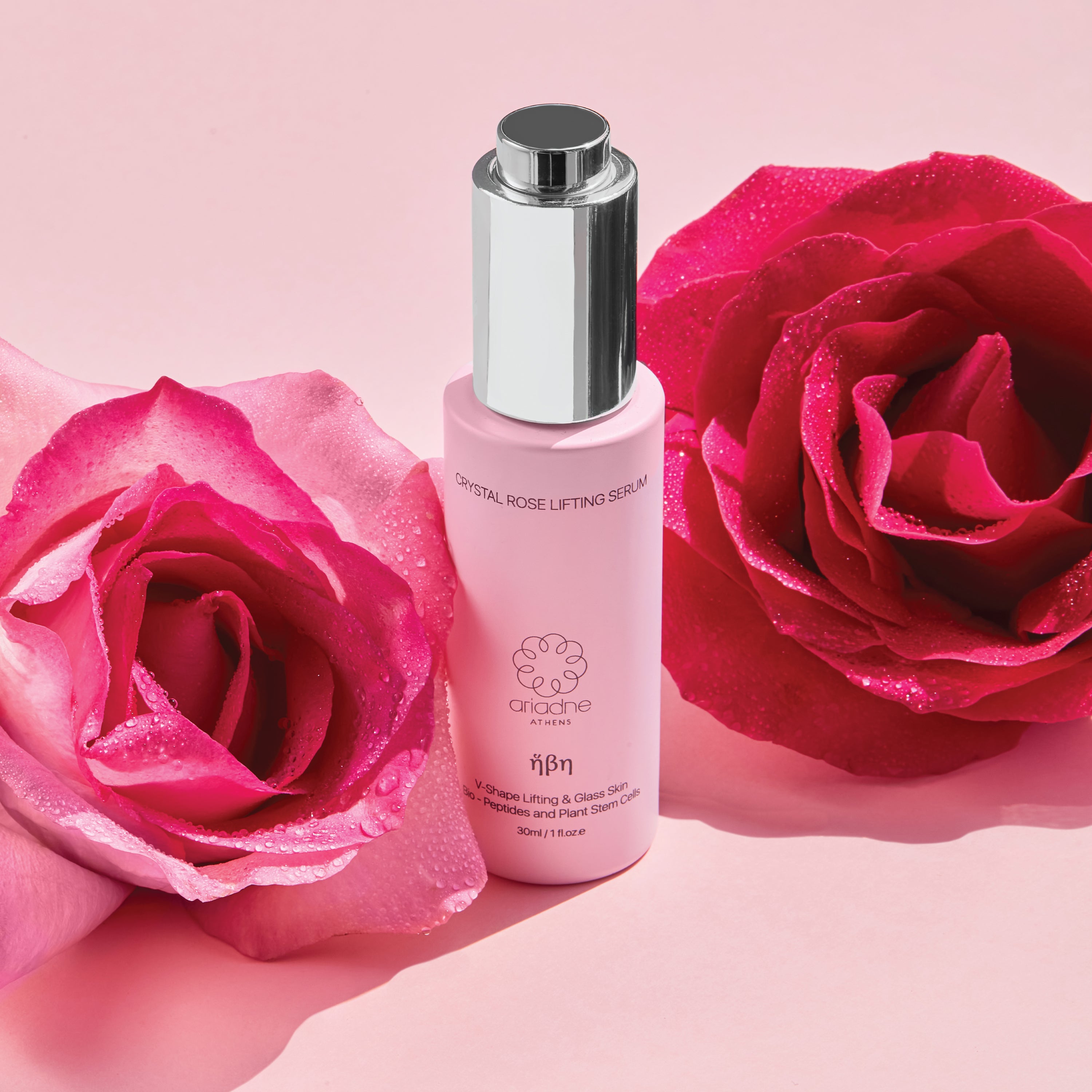 A bottle of the Crystal Rose Lifting Serum detween two red roses.