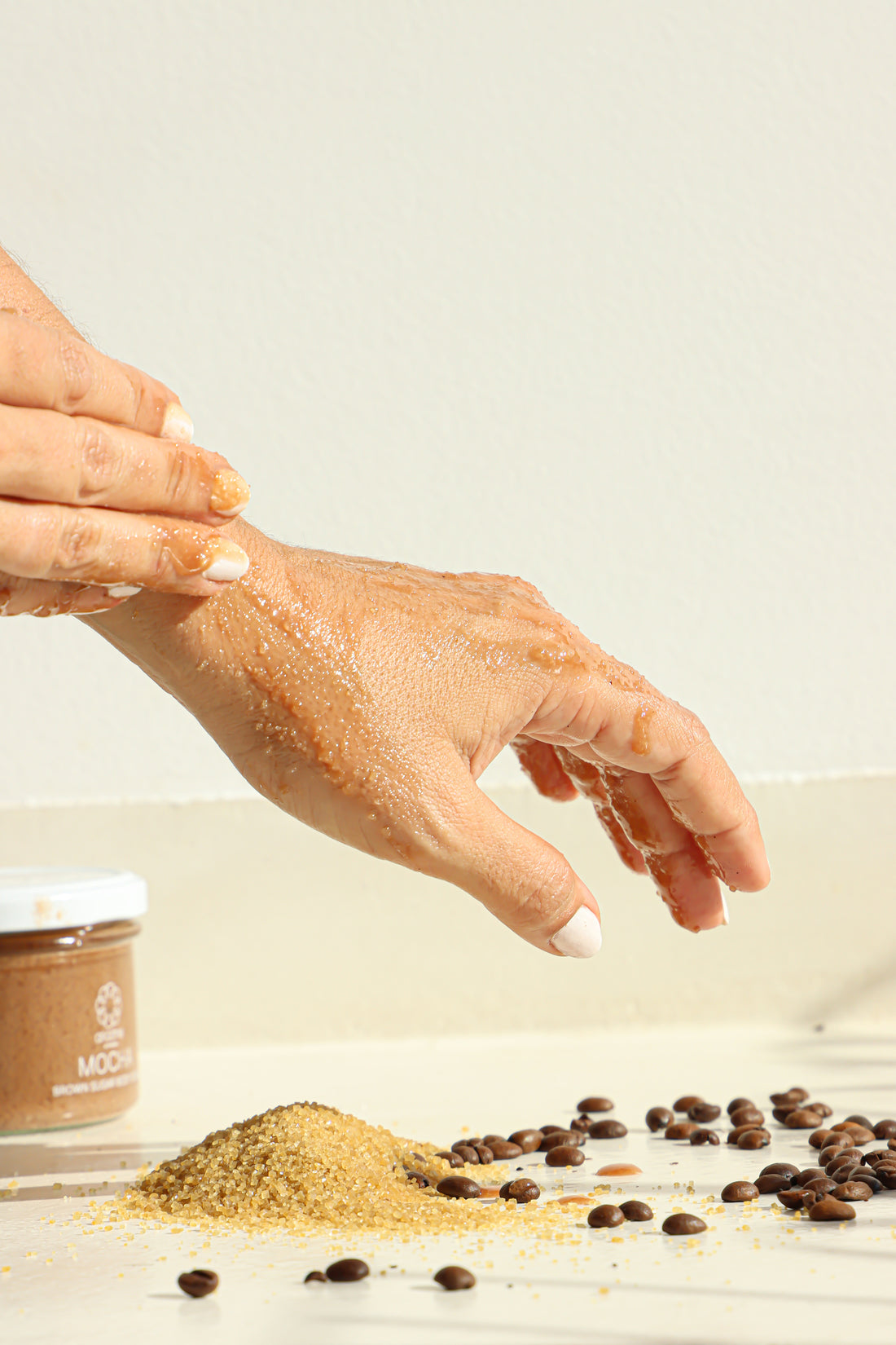 A woman applying the Mocha Brown Sugar Body Scrub on her hands.